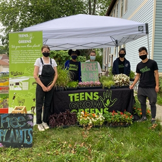 Group photos of teens giving plants away at neighborhood garden