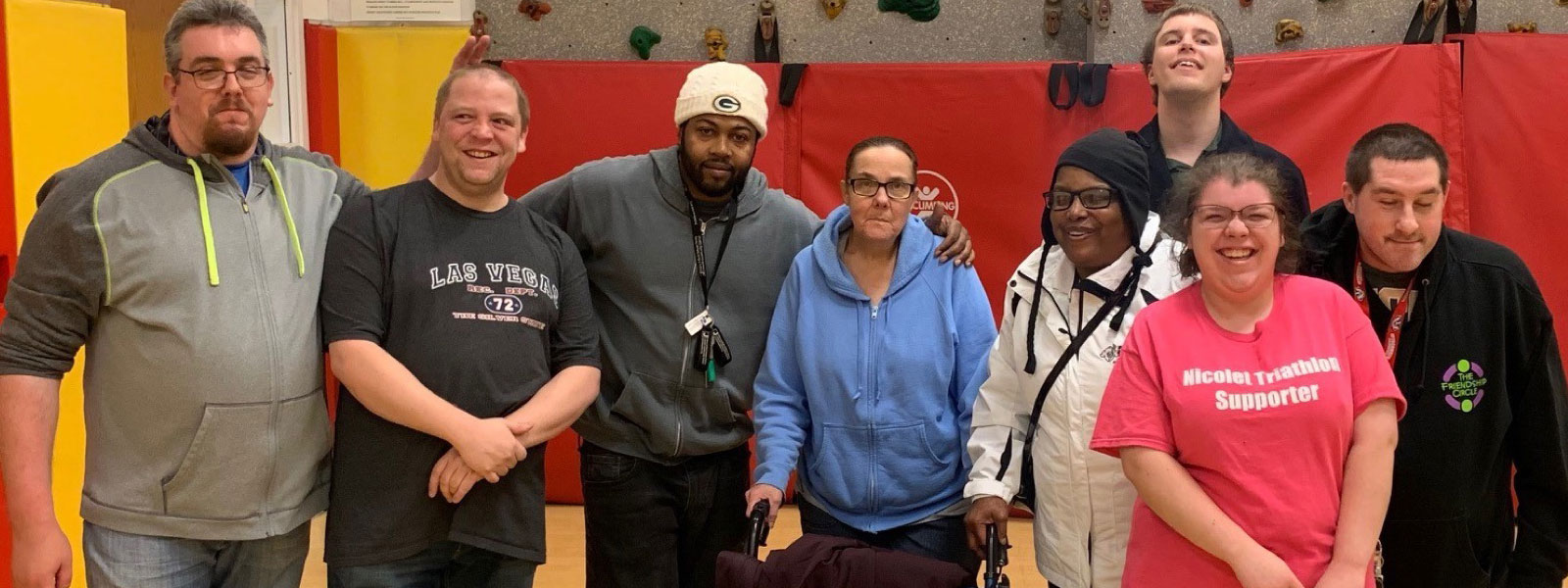 Group of 8 In Front of Climbing Wall