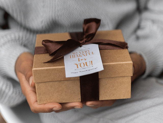 Image of hands holding a wrapped gift. Image of hands holding a wrapped gift.