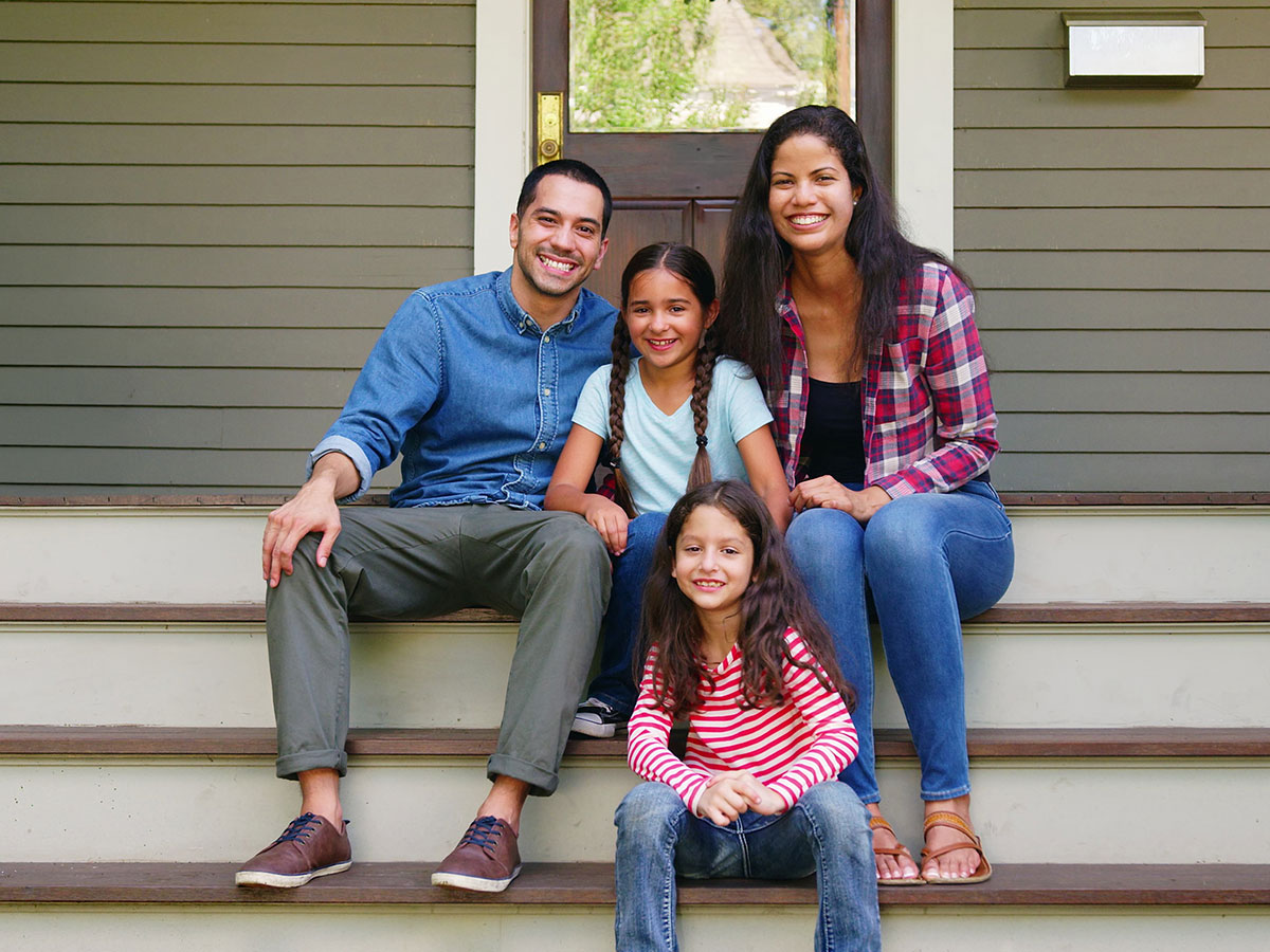 family sitting together on front porch