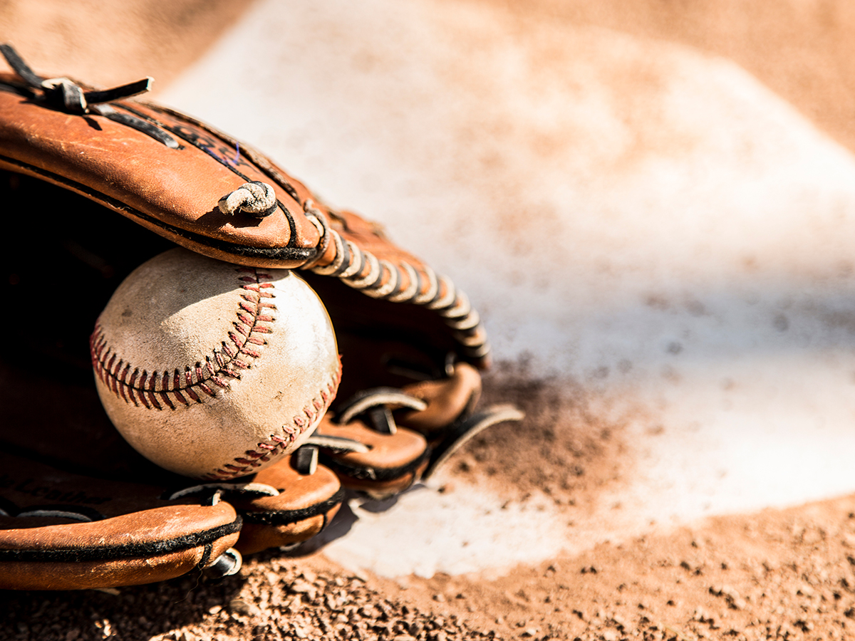 image of baseball in glove on home plate