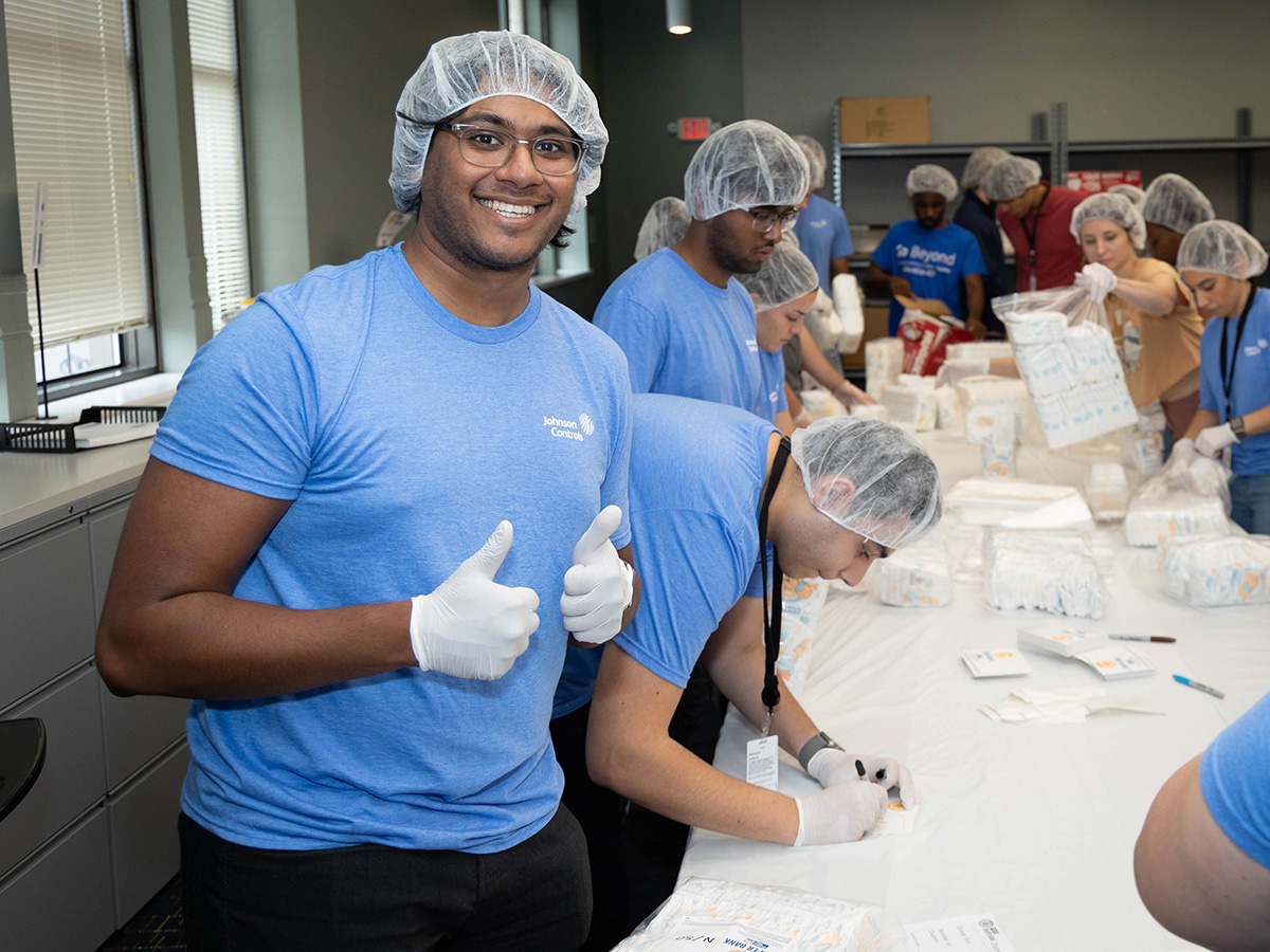 group of people in hair nets packing diapers