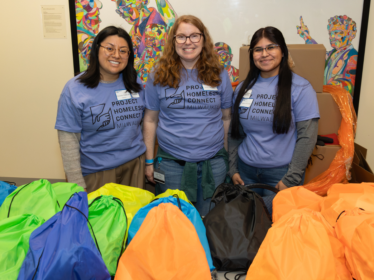 Image of three volunteers with bags at event