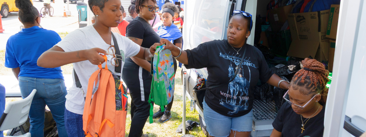 Earn & Learn interns and staff unload backpacks.