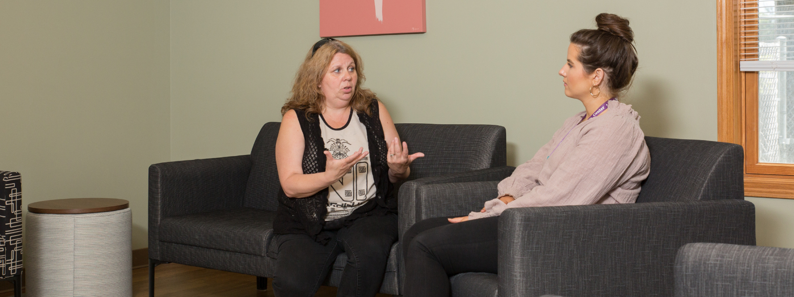 2 women talking on black armchairs
