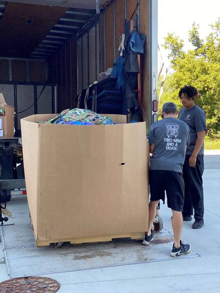 TWO MEN AND A TRUCK team members load backpacks