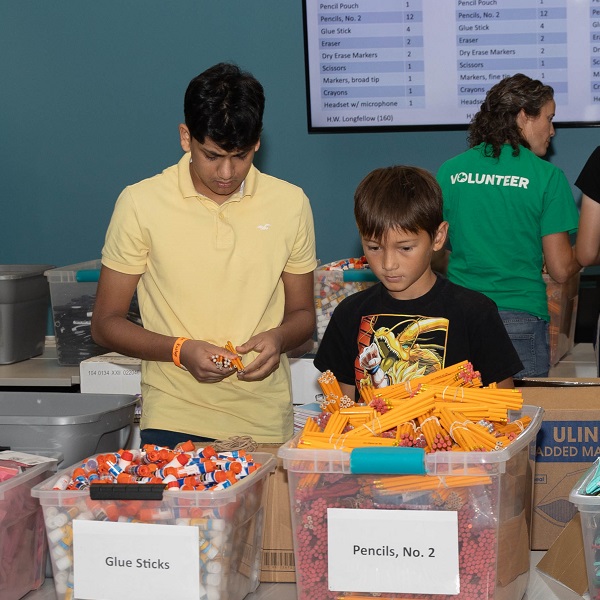 Youth pack backpacks at a 2023 backpack assembly event