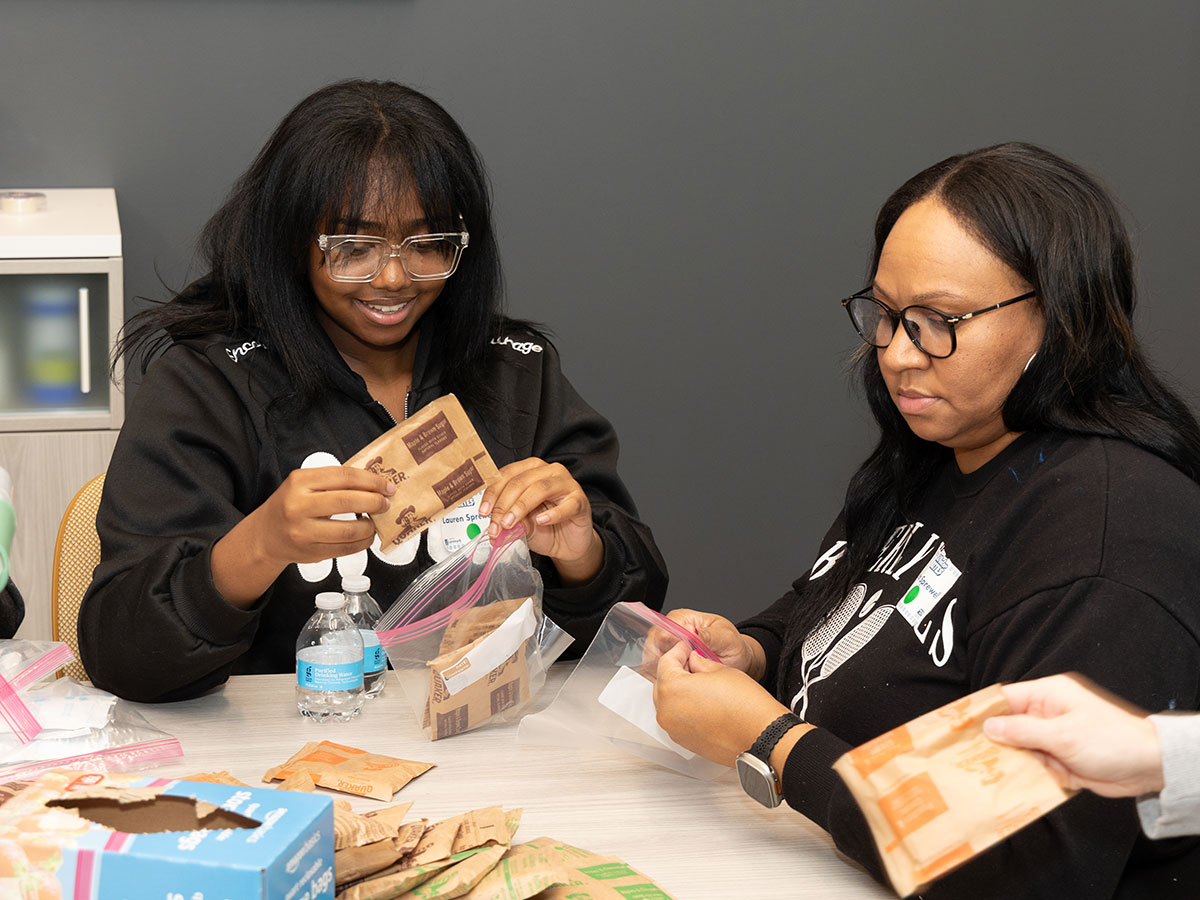 two people packing supplies in plastic bags