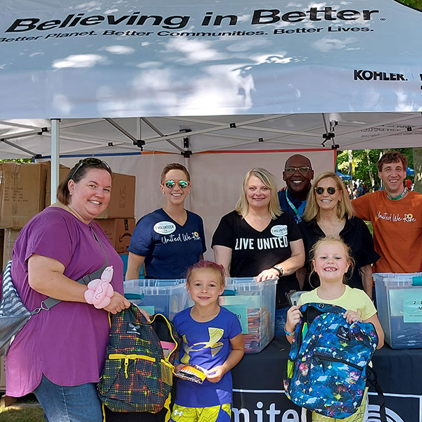 two kids packing backpacks at a volunteer event