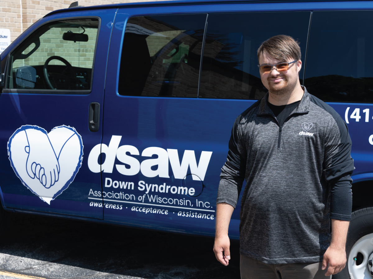 Lukas in front of a Down Syndrome Association of Wisconsin van