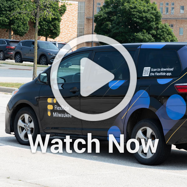 image of van driving down the street with a play overlay button