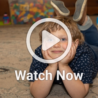 image of boy on the floor with a play overlay button