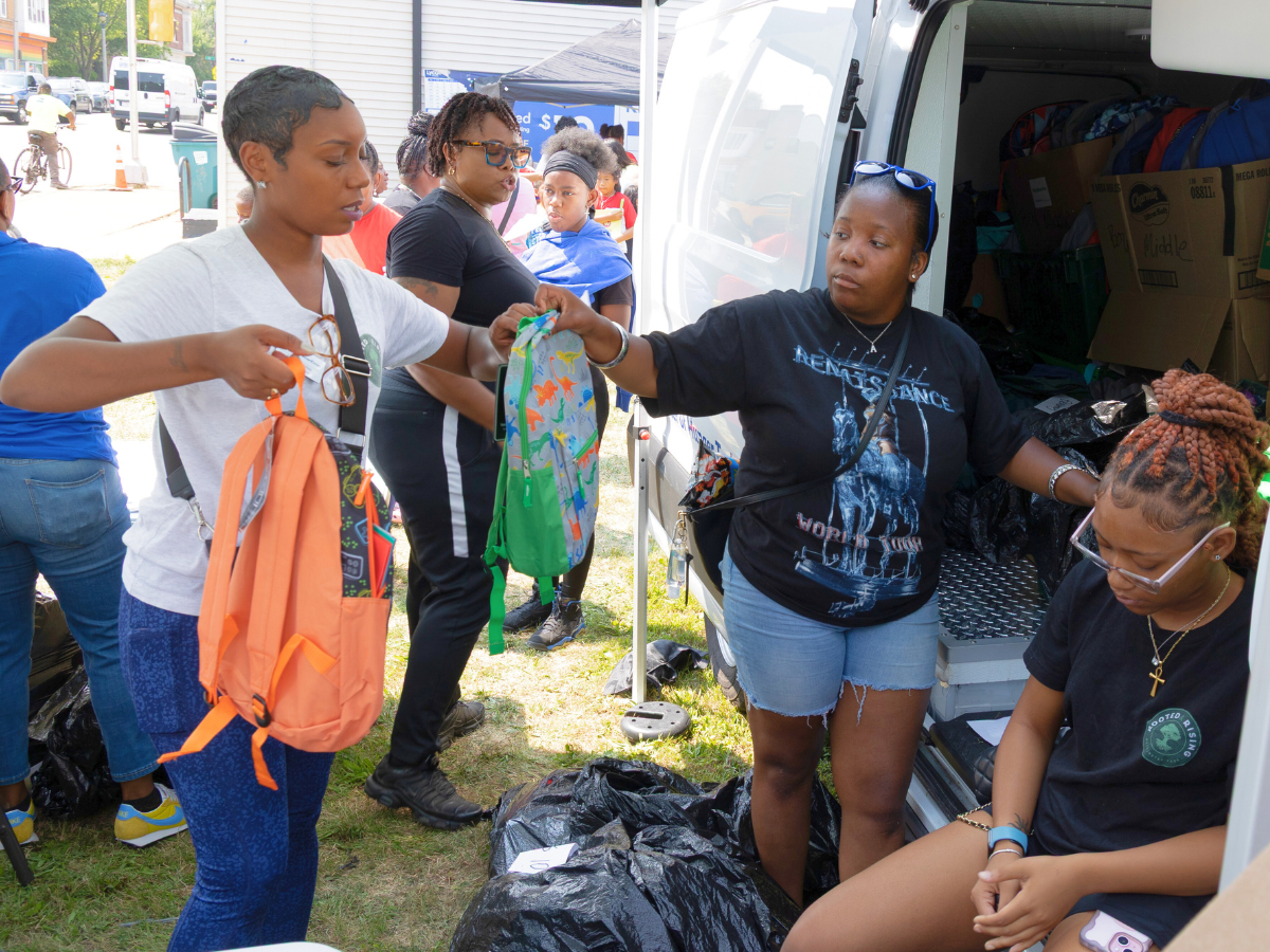 Earn & Learn interns and staff unload backpacks.