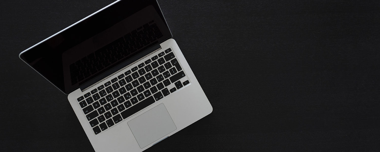 Aerial view of an open macbook on a black background